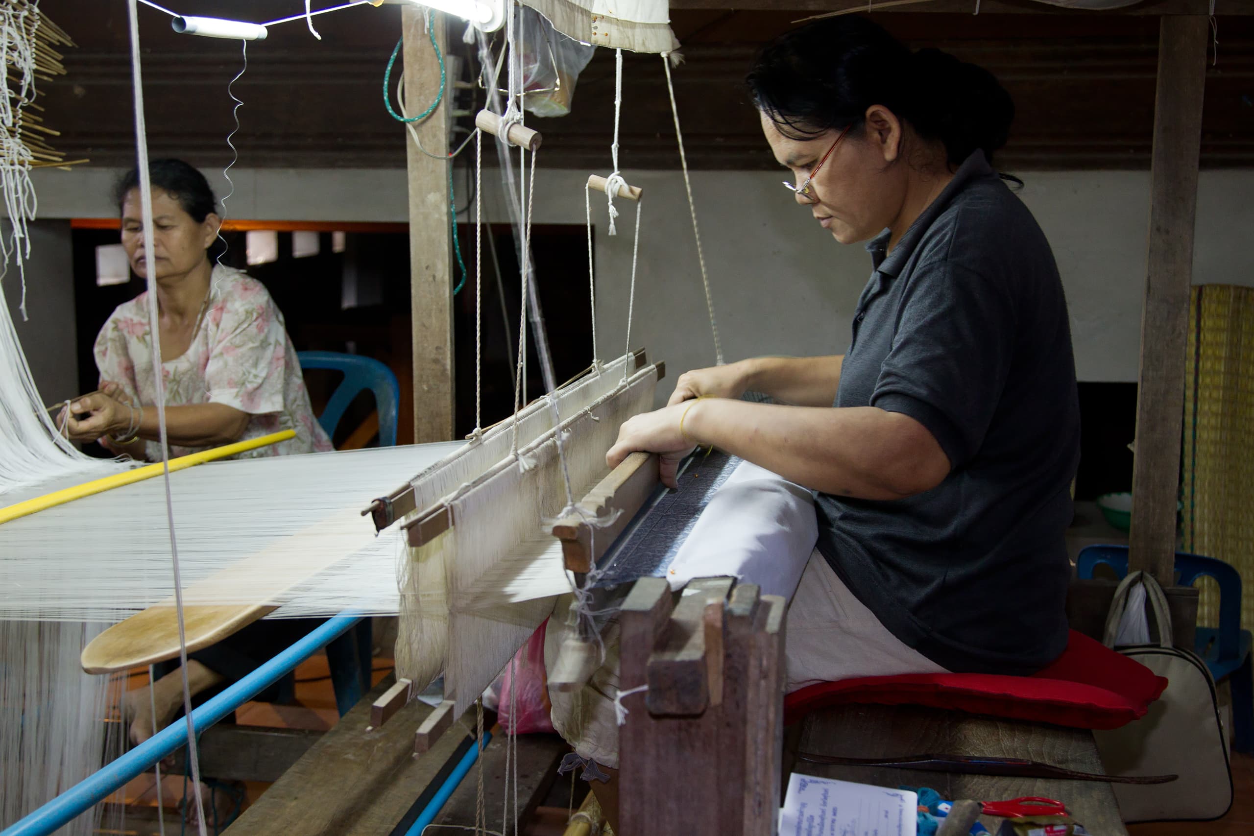 A weaver working silk at a loom